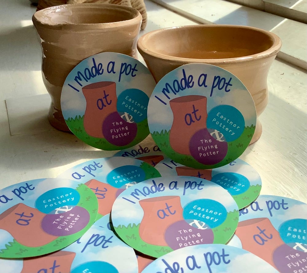 round sticker containing text that reads 'I made a pot at Eastnor Pottery' scattered surrounding hand thrown pots