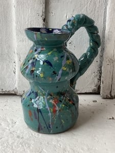 curve shaped jug with textured handle, painted teal and decorated with splattered paint