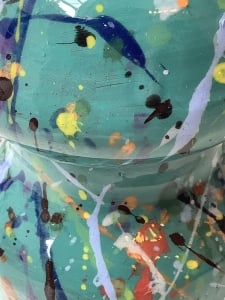 up close image of ceramic teal and decorated with splattered paint