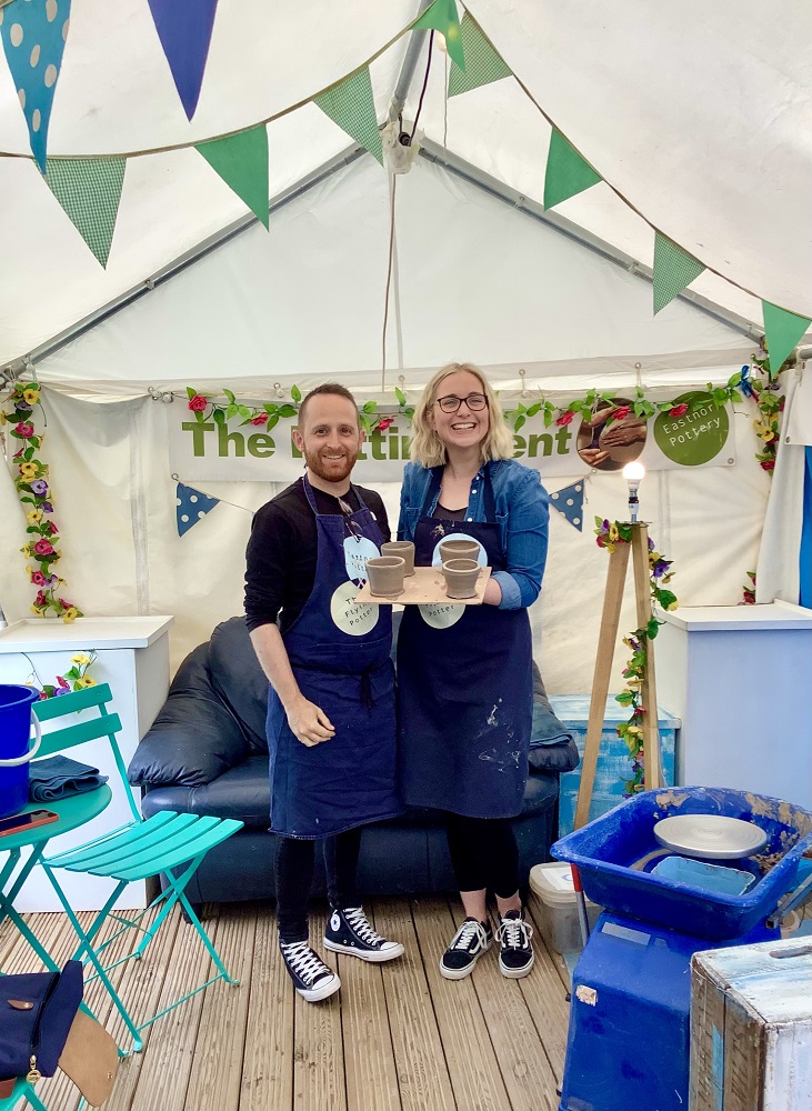man and woman couple holding pots thrown on pottery session inside the potting tent