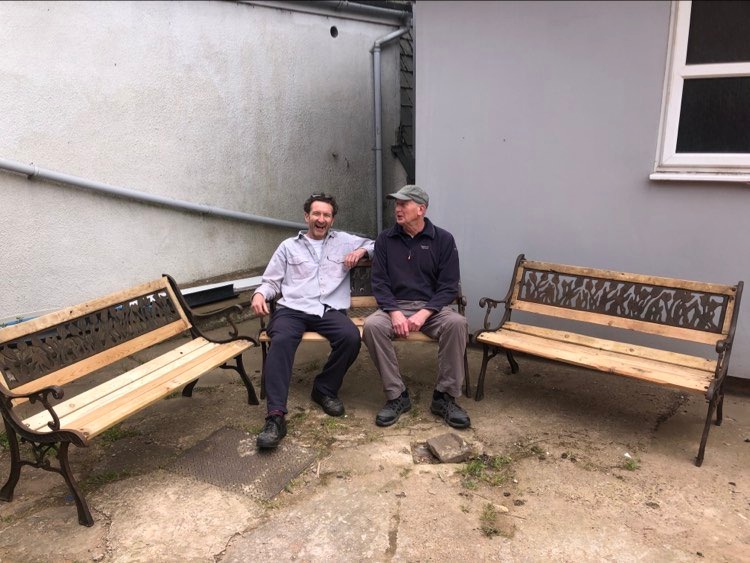 jon williams from eastnor pottery and danny from men's shed sat on restored benches at malvern men's shed