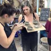 girls inspecting their fresh pots made on the potter's wheel at eastnor pottery
