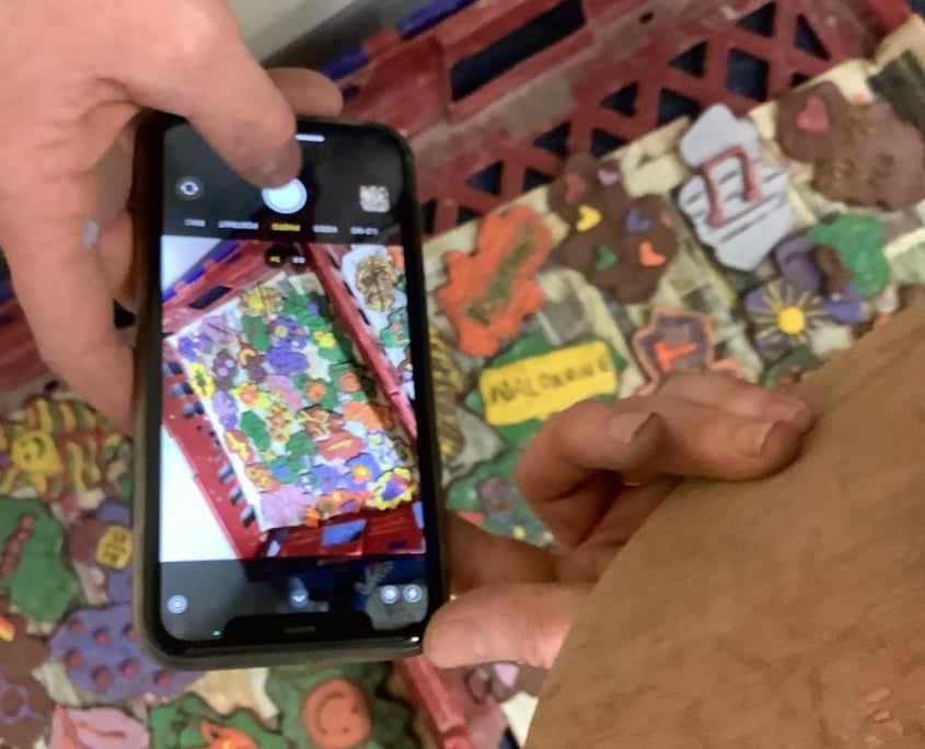 mobile phone taking a photo of freshly made pottery tiles as part of pottery team building day in herefordshire