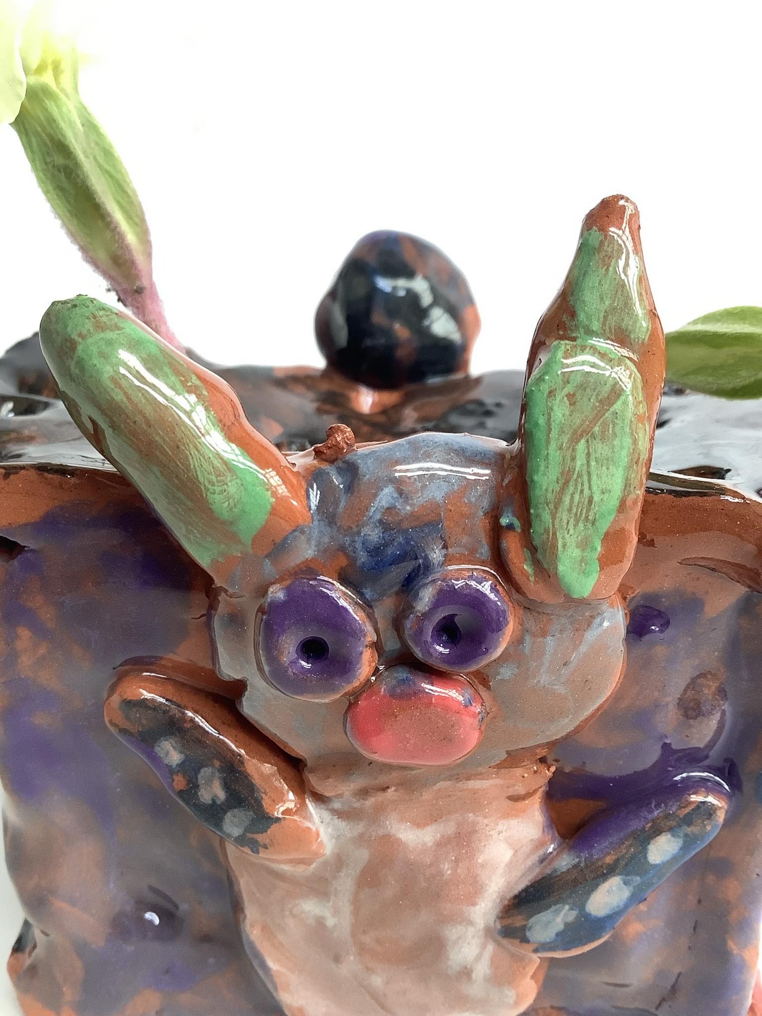 a glazed modelled colourful rabbit modelled to the side of a childs flower brick made on a family workshop at eastnor pottery herefordshire