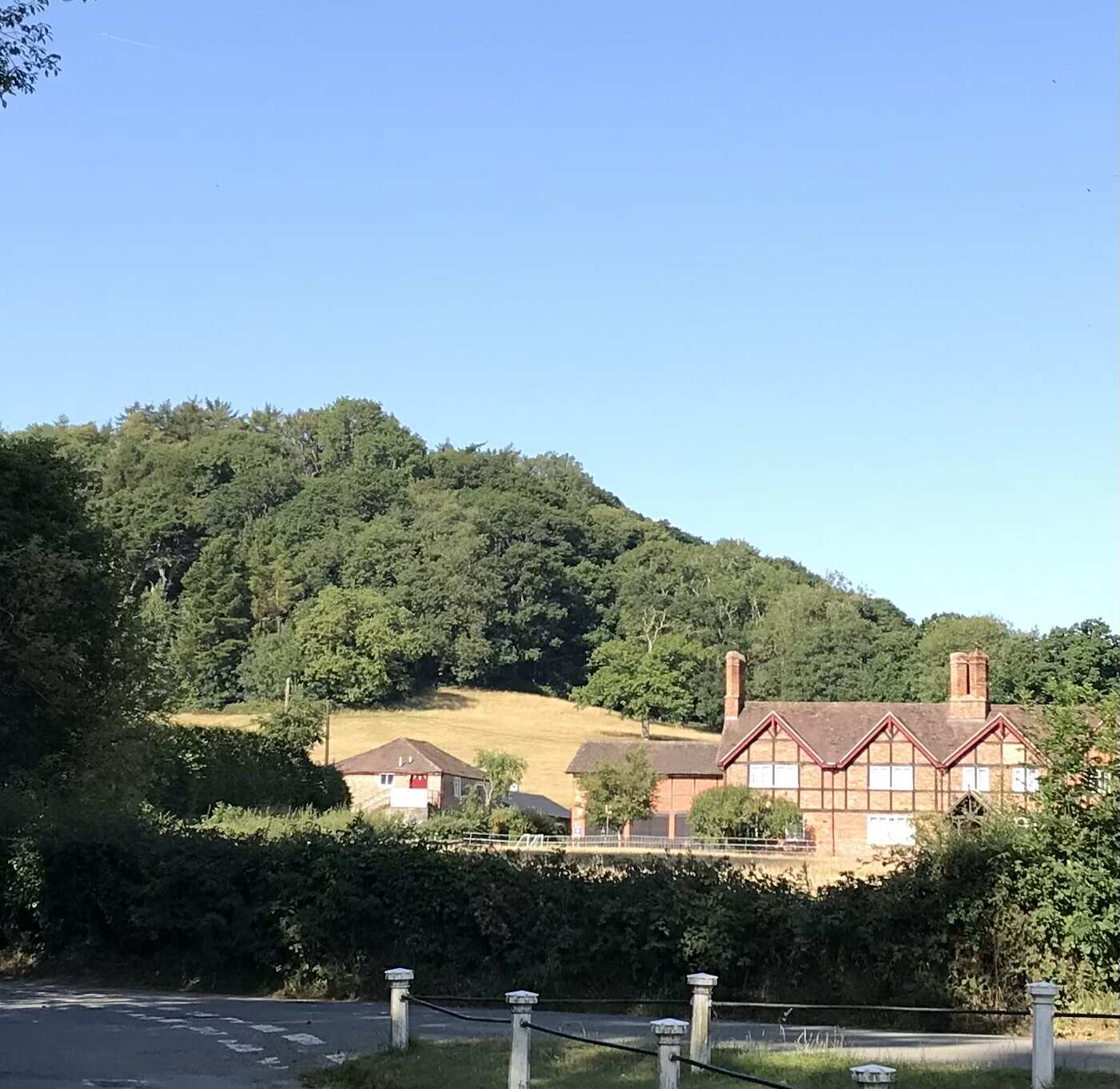 A countryside view of some hills and trees with Eastnor Pottery set below.