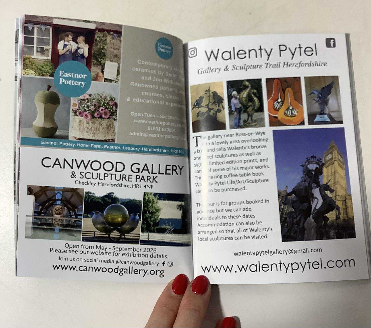 eastnor pottery entry in the little gallery guide 2026 a hand with red painted nails is holding the pages of the guide open at eastnor pottery's page.