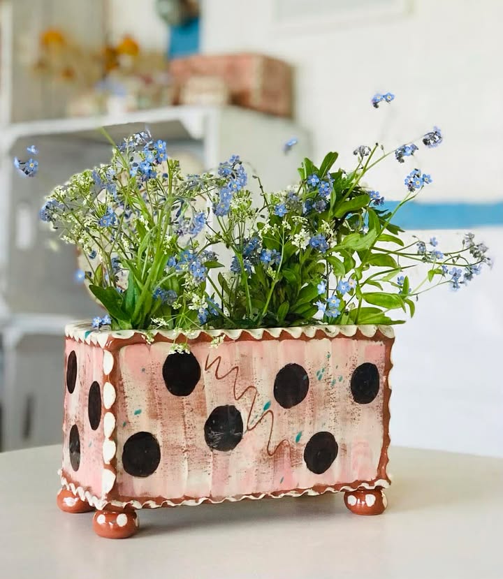 Pink flower brick with large brown dots inside is a flower arrangement of forget-me-nots and may blossom.