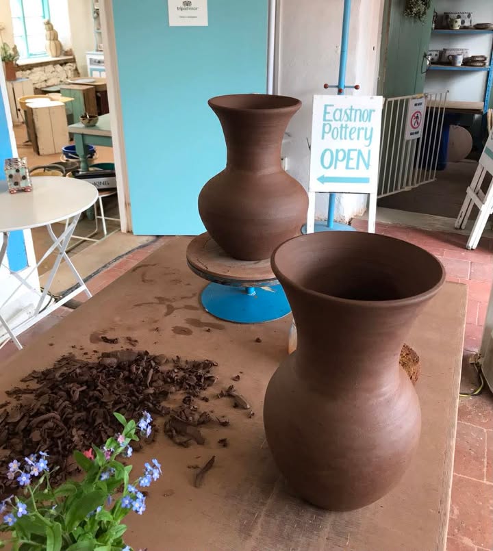 Two large wheel thrown vases on a table awaiting decoration.