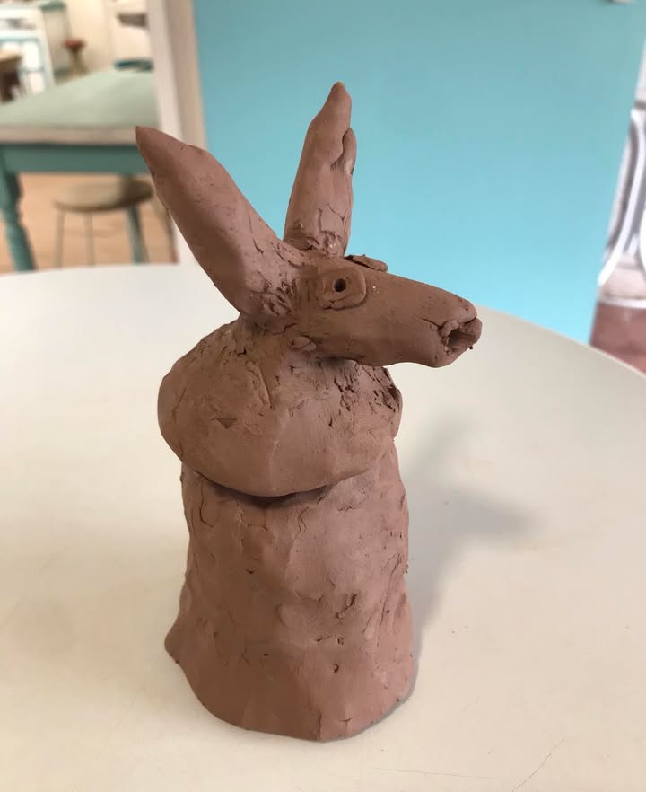 An Egyptian style lidded pot made by a School child. The lid is modelled as an animal head that looks a bit like a horse.