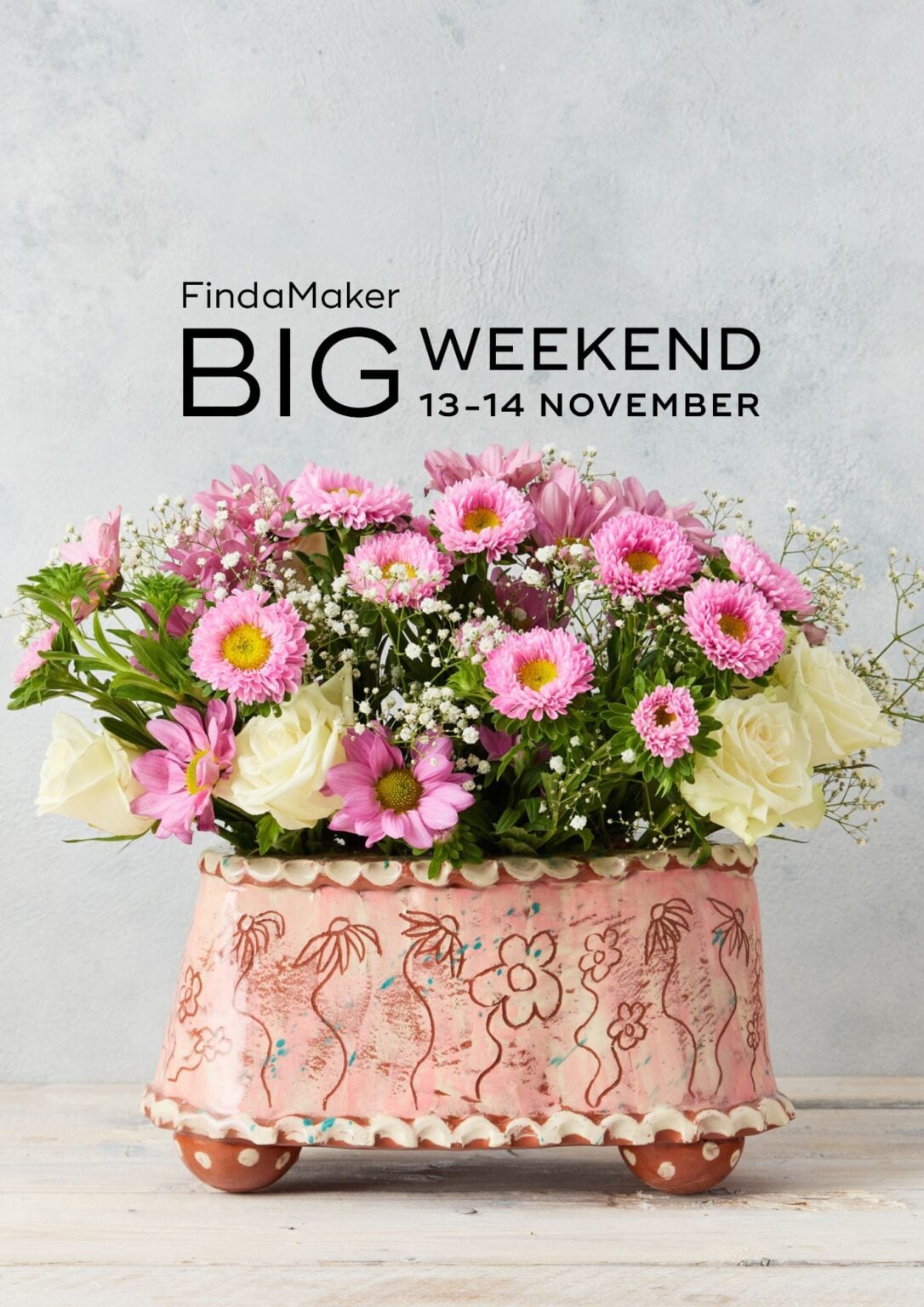 Find a maker Big weekend logo in black set above a pink ceramic flower brick containing an arrangement of fresh flowers.
